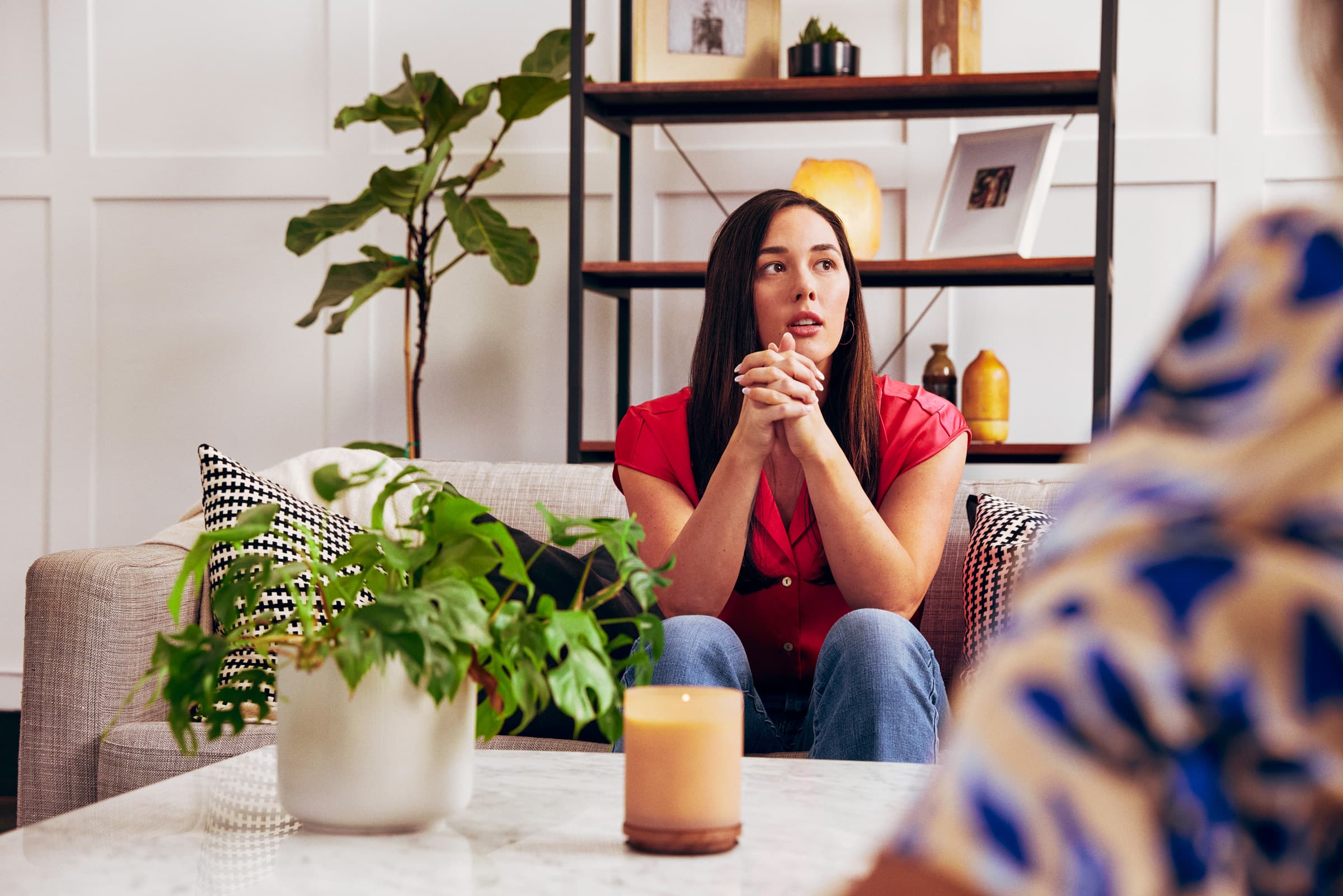 Woman sitting on a sofa, thoughtfully listening during a conversation