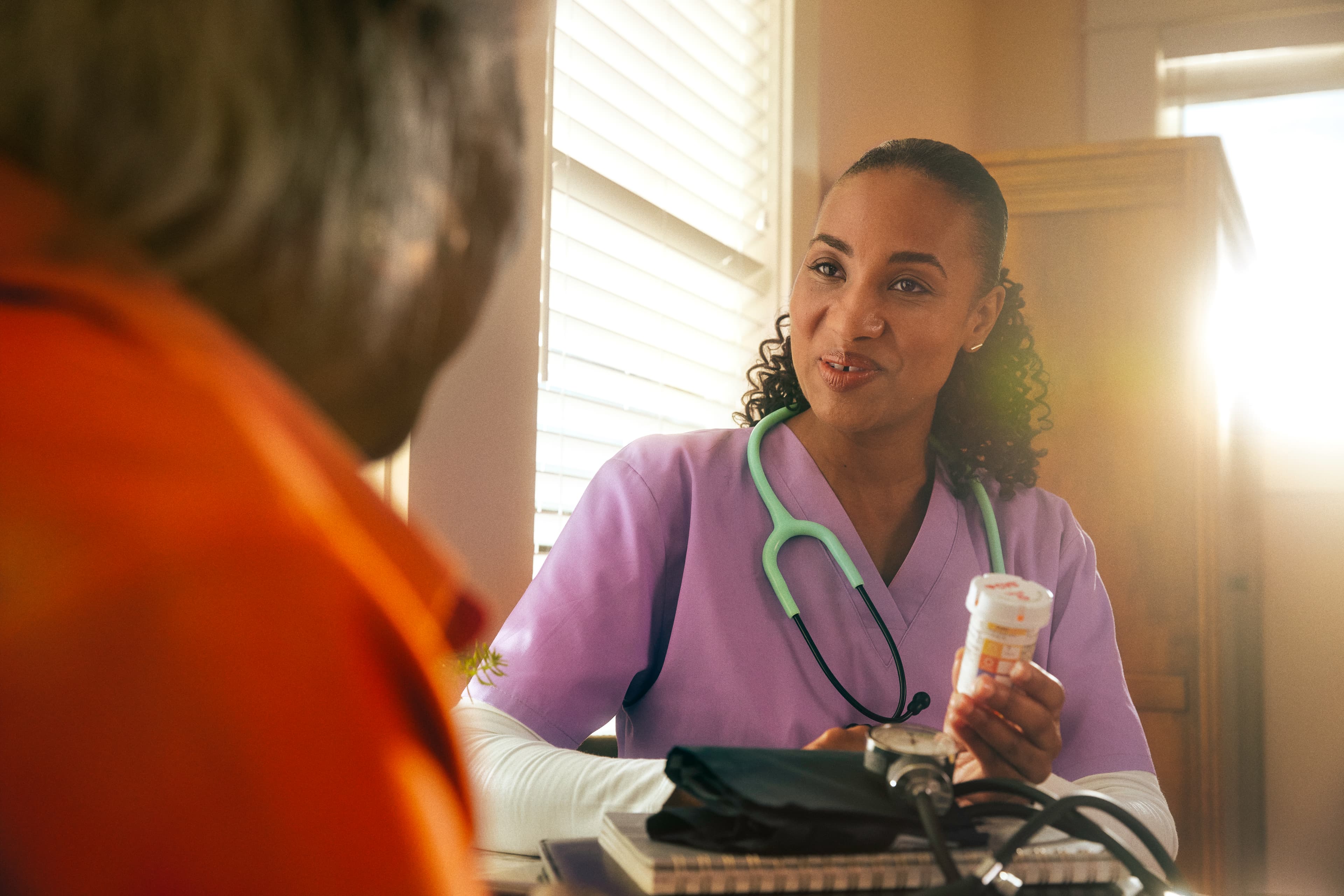 Nurse speaking with a patient and explaining a prescription medication